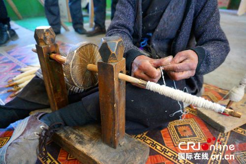 氆氇的手工生产首先要将羊毛用纺锤捻成细线 摄影:刘倡